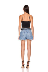Woman wearing a black top and denim shorts on a white background