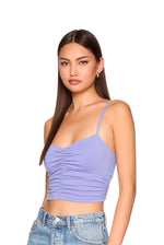 Woman wearing a purple top and blue jeans on a white background