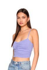Woman wearing a purple top and blue jeans on a white background