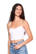 Woman wearing a white tank top and blue jeans on a white background