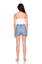 Woman wearing a white top and denim shorts on a white background