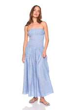 Woman wearing a blue striped strapless dress on a white background