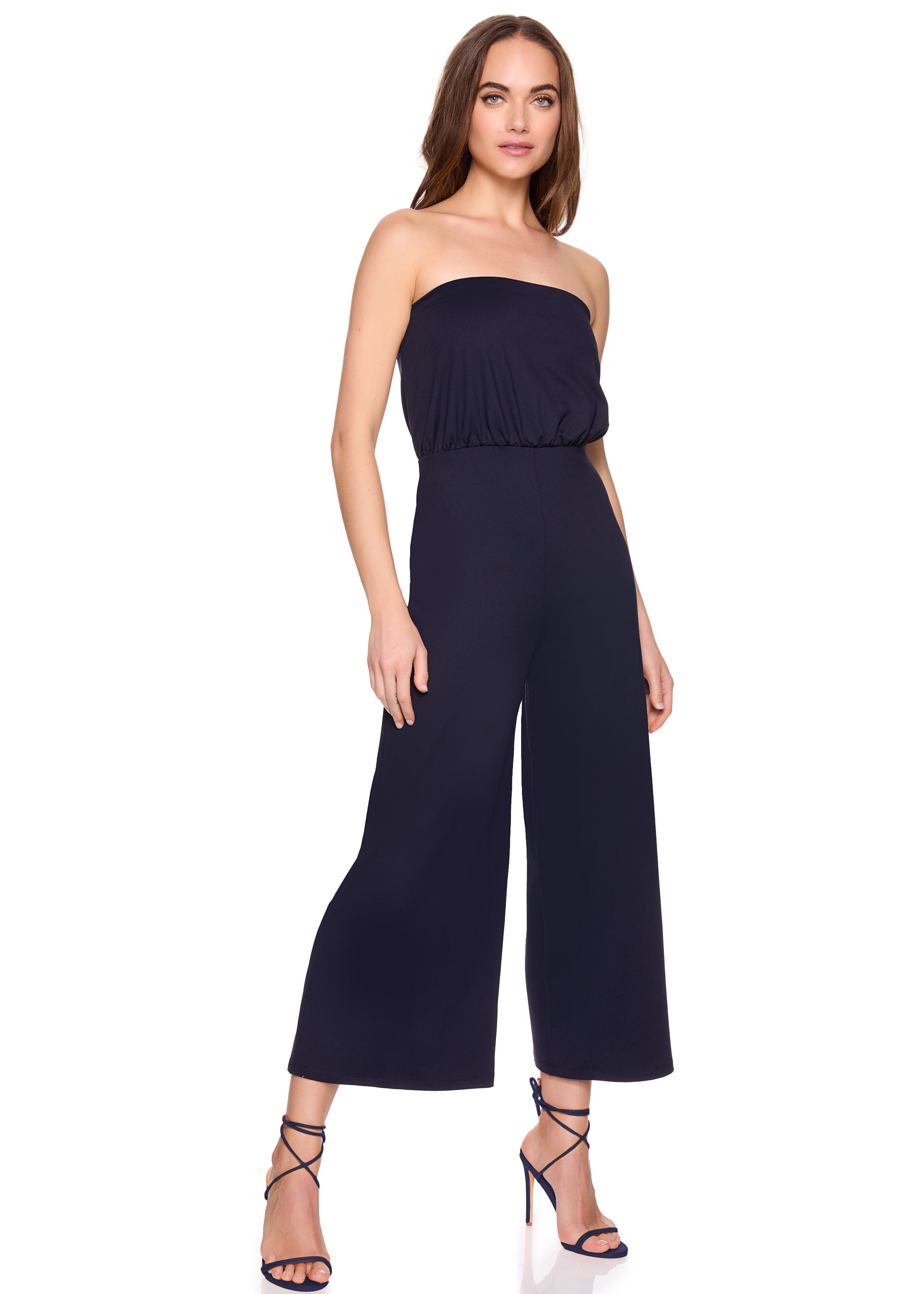 Woman wearing a strapless navy jumpsuit on a white background